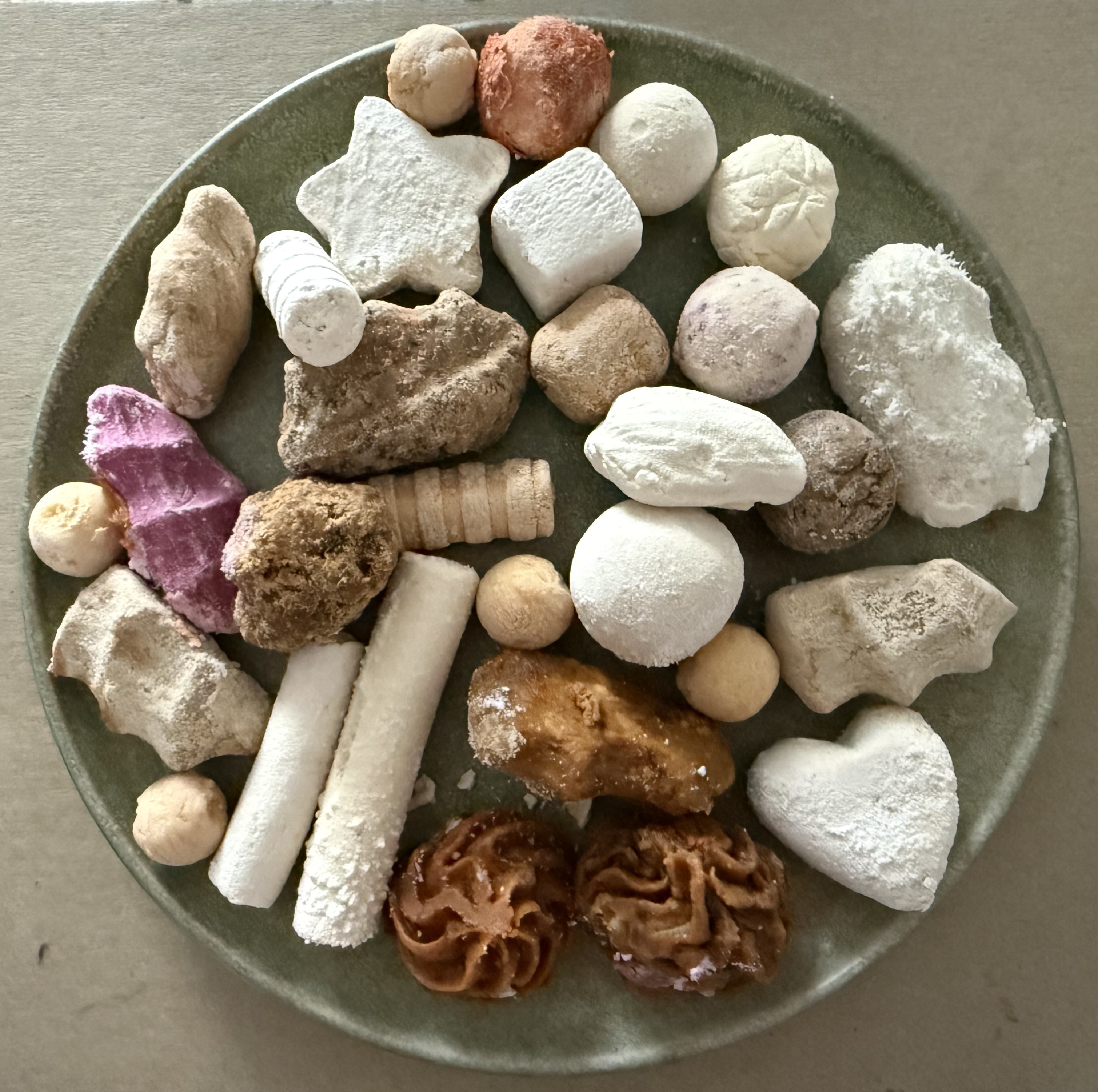 A plate showing several varieties of qurut, hard sour balls of dried yogurt, in different sizes and colors